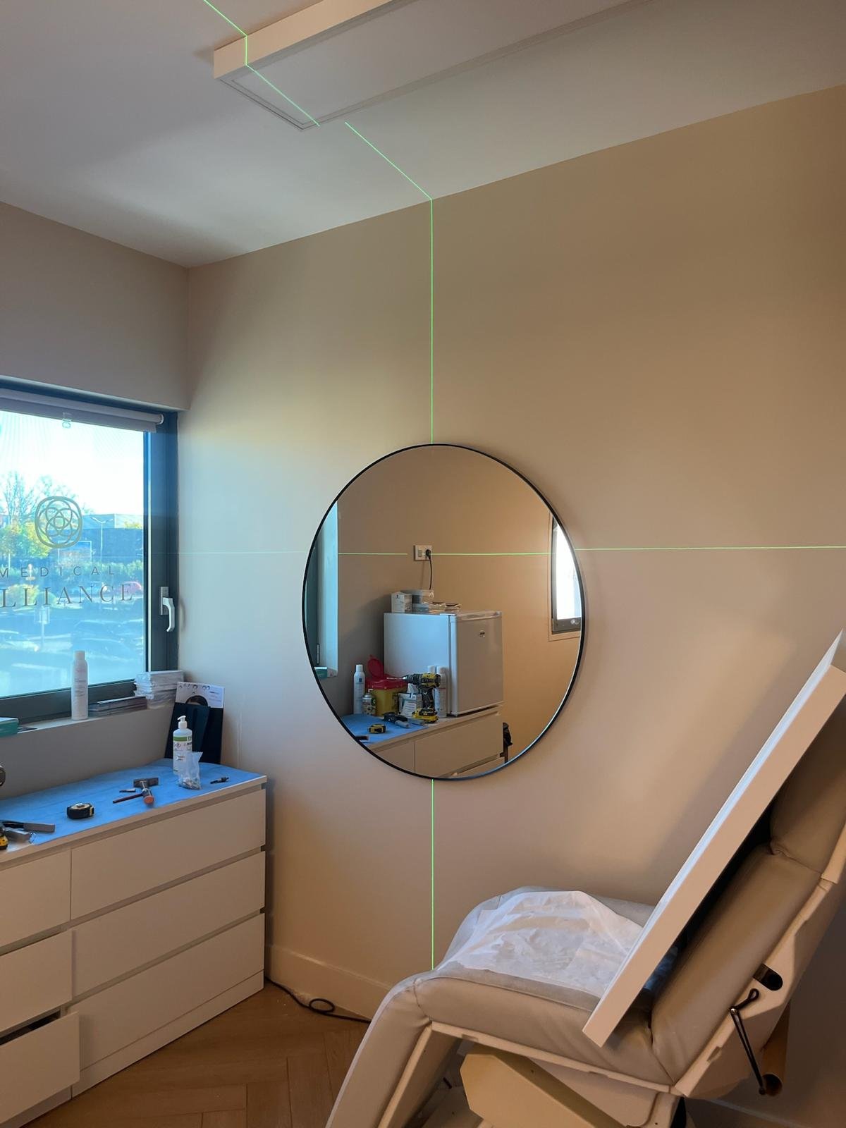 Pièce du centre esthétique en cours de travaux, avec miroir et laser de niveau